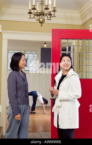 Two Asian women in entryway of house Stock Photo