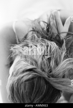 Woman leaning head forward, close-up on head and shoulders, black and white. Stock Photo
