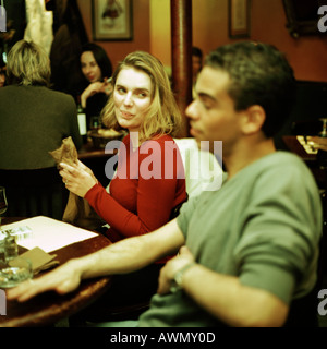 Young man and woman sitting at table in cafe, women looking at man. Stock Photo