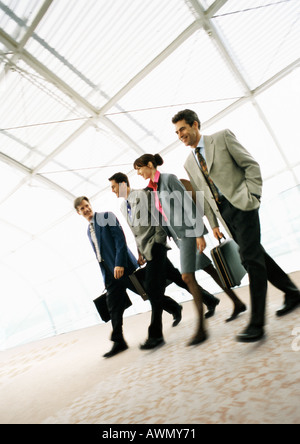 Group of business people walking with briefcases, indoors Stock Photo