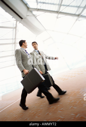 Businessmen walking together with briefcases, indoors. Stock Photo