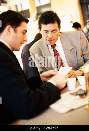 Businessmen looking at paper over coffee. Stock Photo