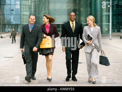 Group of business people walking together outside, full length, front view Stock Photo