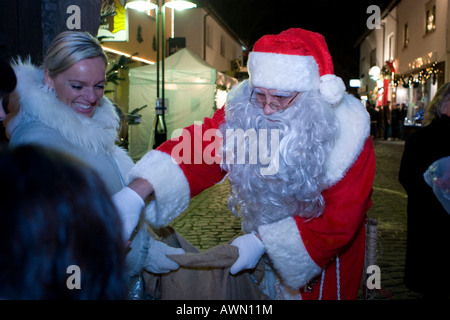 Santa Claus giving out sweets on a christmas market, Hesse, Germany Stock Photo