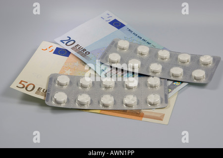 Prescription drugs are getting more expensive: pills in blister packs lying on top of Euro notes Stock Photo