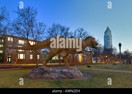 Dinosaur sculpture at the Senkenberganlage site with view of the Messeturm (Trade Show Tower), Frankfurt, Hesse, Germany, Europe Stock Photo