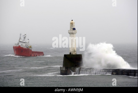 Oil supply vessel struggles to get into Aberdeen Harbour, Scotland, UK, during rough seas after a storm in winter Stock Photo