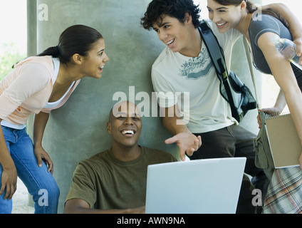 College students looking at laptop and laughing Stock Photo