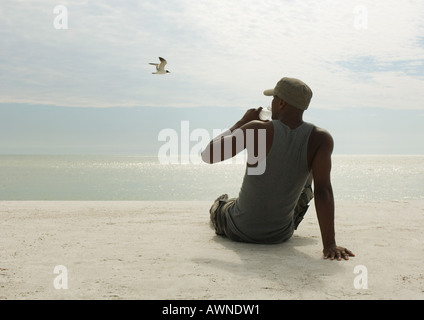 Man drinking water on beach Stock Photo