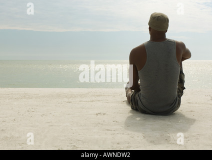 Man looking at view on beach Stock Photo