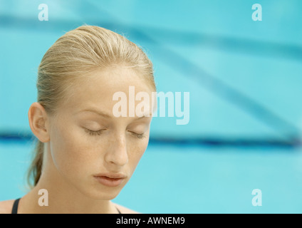 Woman, eyes closed, pool in background Stock Photo