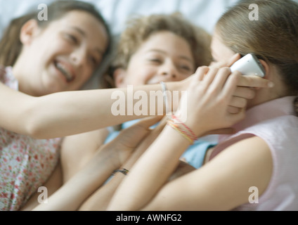 Preteen girls using cell phone, giggling Stock Photo