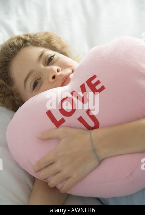 Preteen girl holding heart pillow