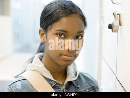 Teen girl standing next to locker
