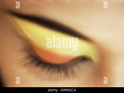 Woman's closed eye with yellow and orange eye shadow, close-up Stock Photo