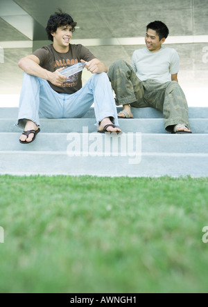Two male college students sitting on steps together Stock Photo