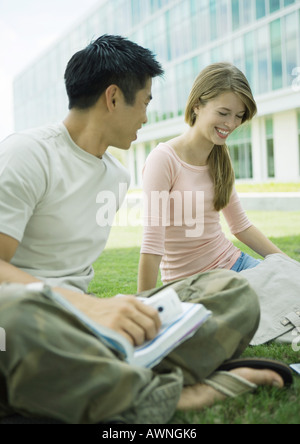 Two college students sitting on ground, studying Stock Photo