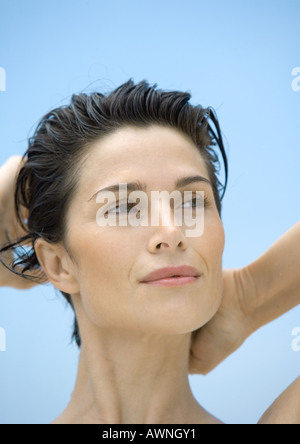Woman with hands behind head Stock Photo