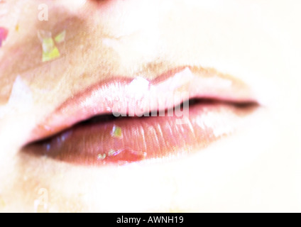 Woman wearing pink lipstick, close up of mouth with confetti. Stock Photo