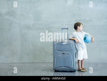 Boy with suitcase and globe Stock Photo