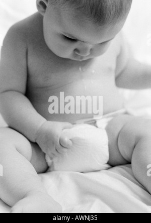Baby playing with diaper, B&W. Stock Photo