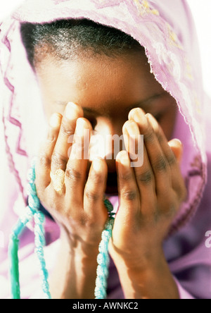 Muslim woman praying with prayer beads, close-up Stock Photo