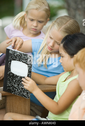 Group of children looking at notebook together Stock Photo