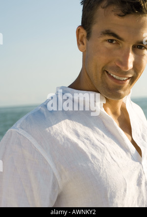 Man smiling, sea in background Stock Photo