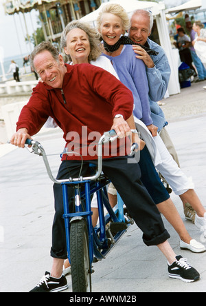 Mature men and women on stationary tandem bike, portrait Stock Photo