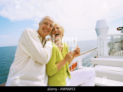 Mature couple posing on boat deck, laughing Stock Photo