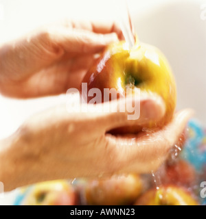Person washing apples, close-up, blurry Stock Photo