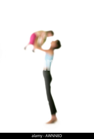 Silhouette of woman holding up child in air, on white background, defocused Stock Photo