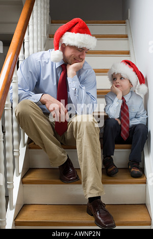 A bored father and son sat on stairs
