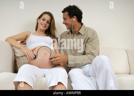 A womans bump listening to music Stock Photo