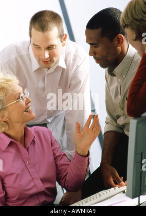 Mature businesswoman talking to other businesspeople Stock Photo