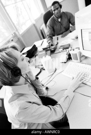Businesswoman and colleague wearing headsets, B&W Stock Photo