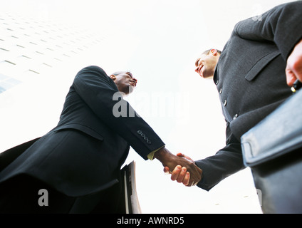 Two businessmen shaking hands, low angle view Stock Photo