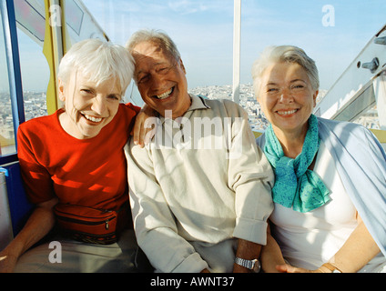Mature man and women sitting in ferris wheel, smiling, portrait Stock Photo