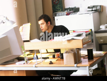 Man looking at slides, sitting at desk Stock Photo