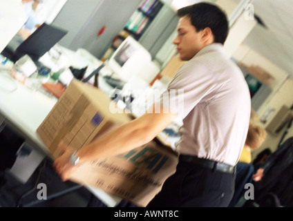 Man placing box on desk, blurred Stock Photo