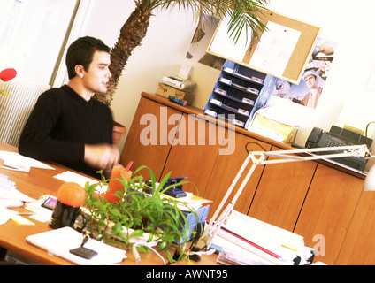 Man sitting at desk in office, side view Stock Photo