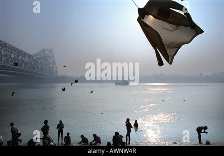 Devotees bathe in the Hooghly River, a branch of the Ganges, near Howrah Bridge Stock Photo