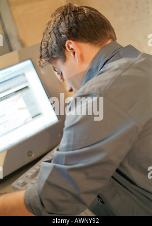 Man working on computer, rear view Stock Photo