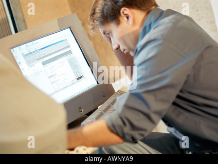 Man working on computer, side view Stock Photo