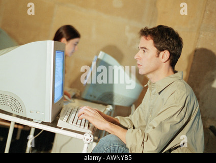 Man and woman working on computers Stock Photo