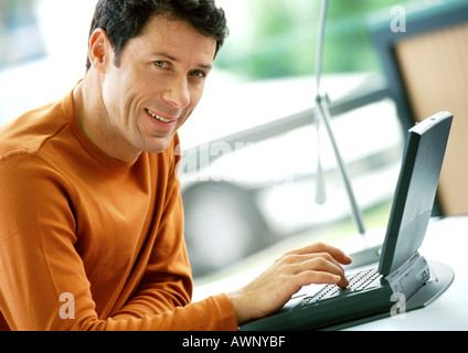 Man using laptop computer, portrait Stock Photo