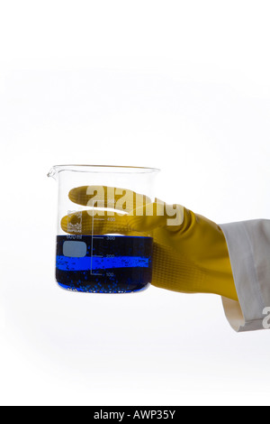 Hand holding a beaker containing blue liquid Stock Photo