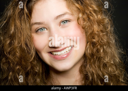 Smiling young woman with long, curly hair Stock Photo