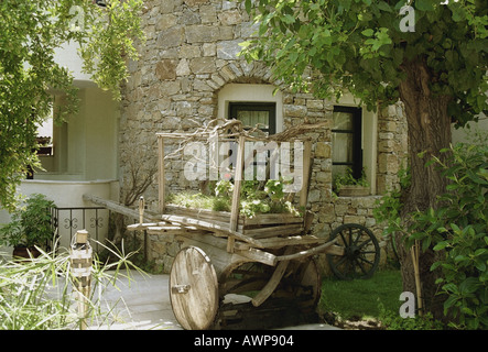 Wooden wagon Europe Asia Turkey Marmaris broken wooden cart telega carriage dry arid branch twig flower house wall stone rock Stock Photo