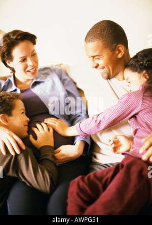 Couple sitting with children, smiling Stock Photo